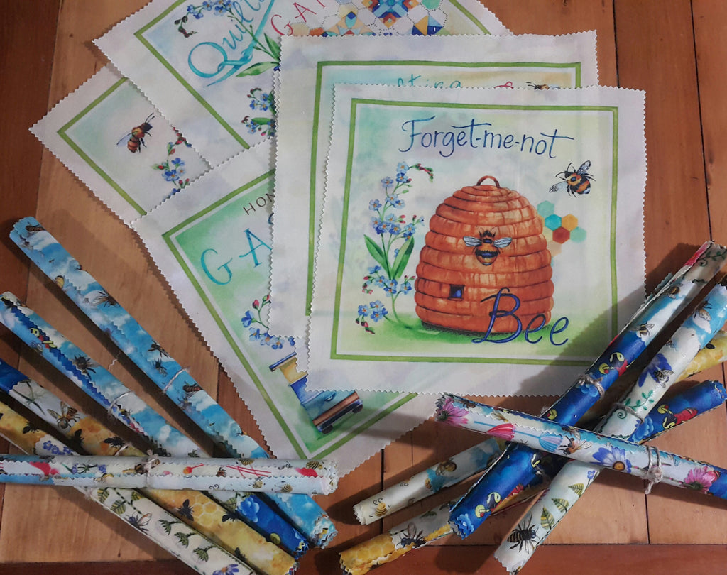 Collection of fabric swatches with bee-themed designs on a wooden surface