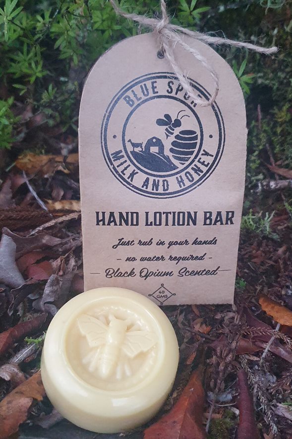 Hand lotion bar with a 'Blue Spur Milk and Honey' label on a natural background