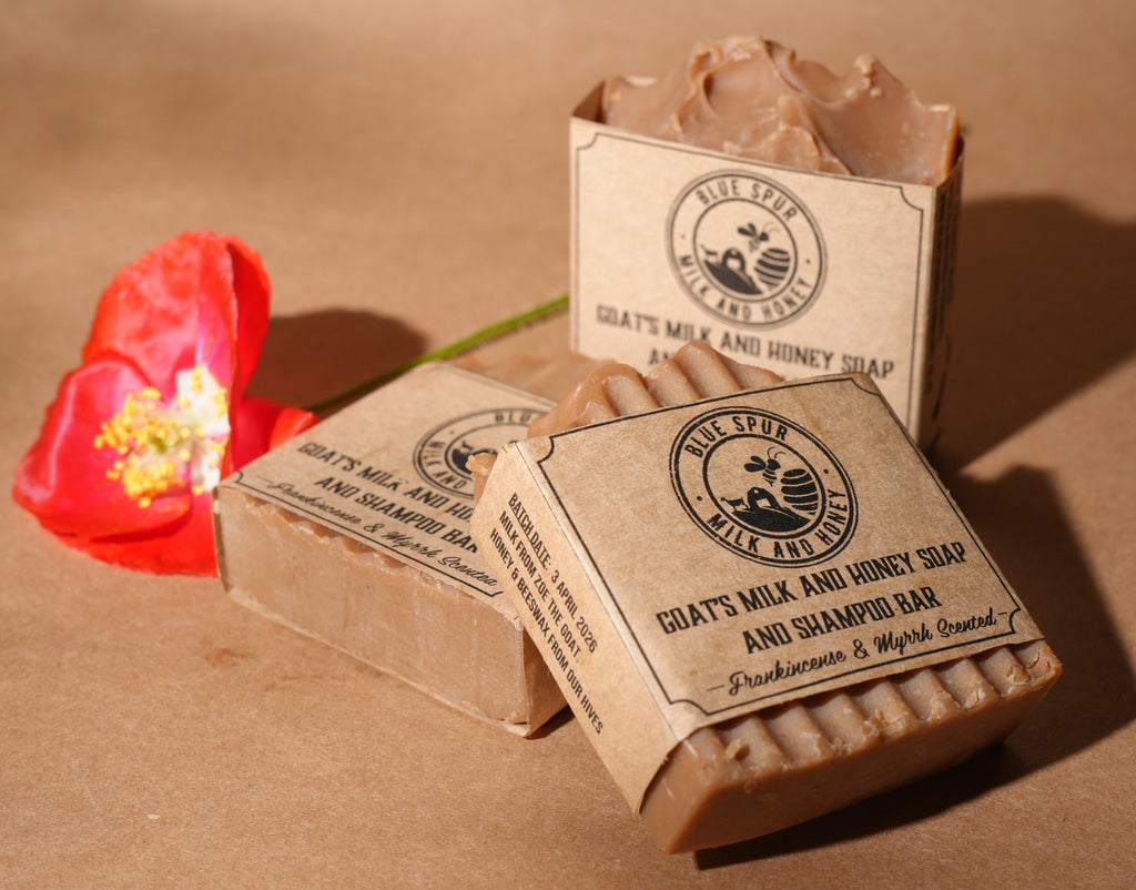 Three soaps with paper packaging. with a brown background and a red poppy