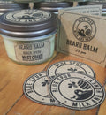 A jar of beard balm with a label reading 'BEARD BALM BLACK OPUMM' and three round beard balm sticks with 'MILK AND HONEY' and 'BEARD BALM' text, indicating the product is related to beard care.
