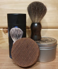 Round brown shaving soap with a tin and a brush